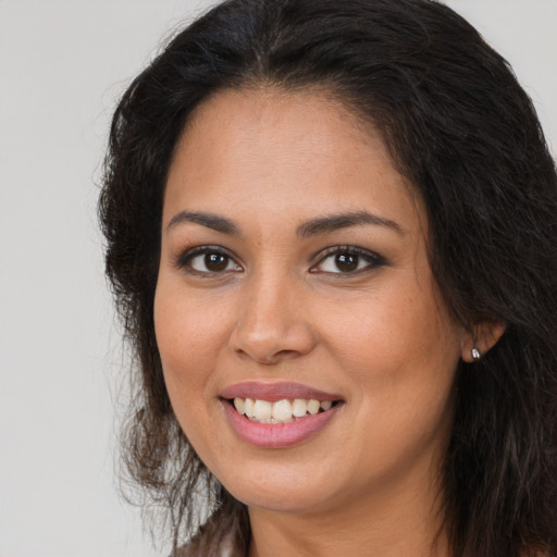 Joyful latino young-adult female with long  brown hair and brown eyes