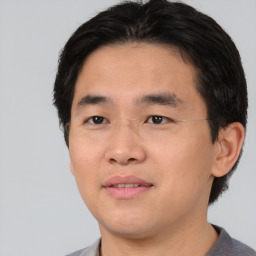 Joyful asian young-adult male with short  black hair and brown eyes