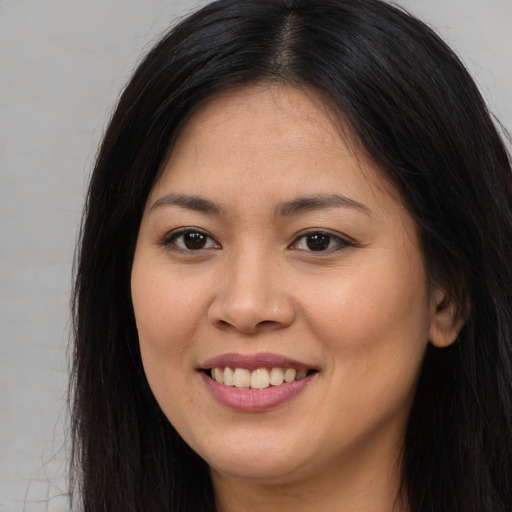 Joyful asian young-adult female with long  brown hair and brown eyes