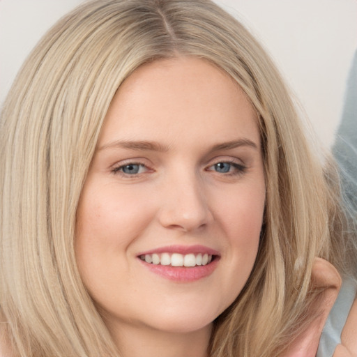 Joyful white young-adult female with long  brown hair and blue eyes