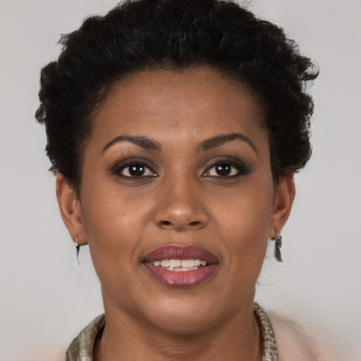 Joyful black young-adult female with short  brown hair and brown eyes