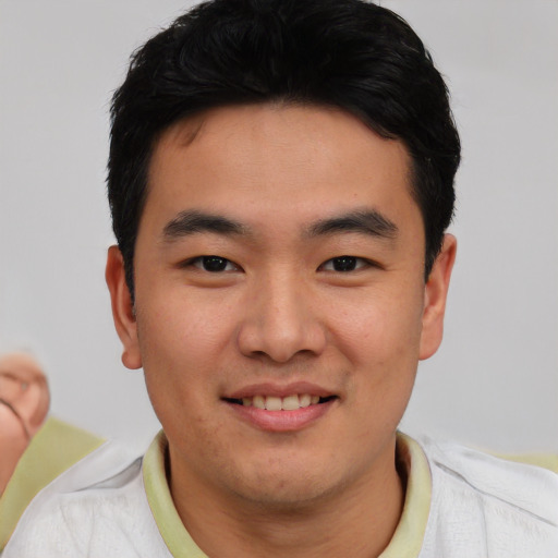 Joyful asian young-adult male with short  brown hair and brown eyes