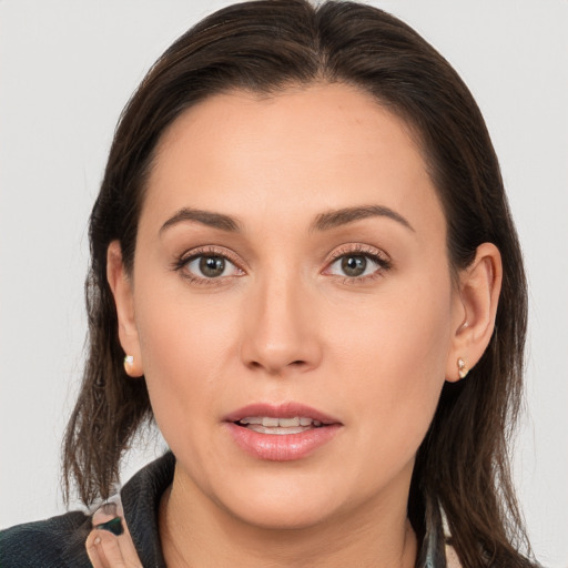 Joyful white young-adult female with long  brown hair and brown eyes