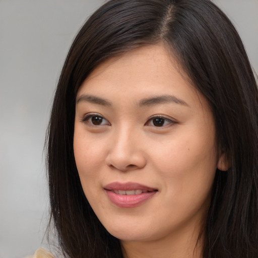 Joyful asian young-adult female with long  brown hair and brown eyes