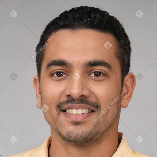 Joyful latino young-adult male with short  black hair and brown eyes