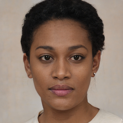 Joyful black young-adult female with short  black hair and brown eyes