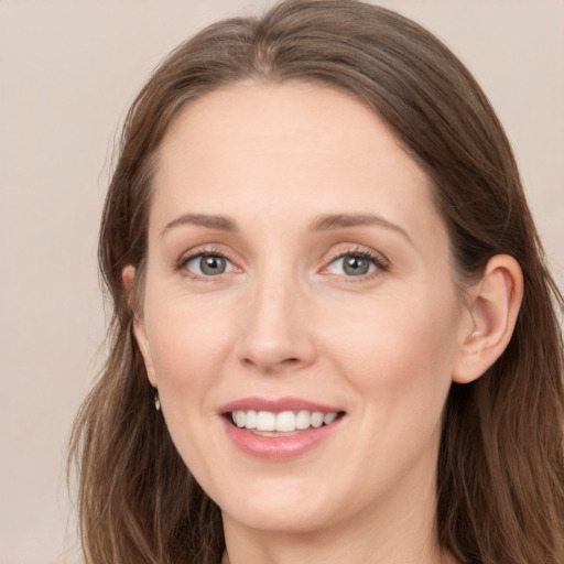 Joyful white young-adult female with long  brown hair and grey eyes