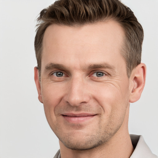 Joyful white adult male with short  brown hair and grey eyes