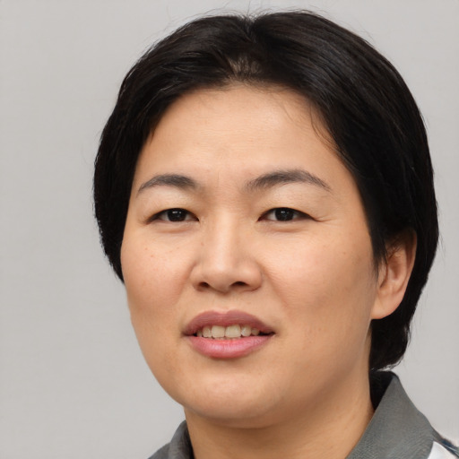 Joyful asian young-adult female with medium  black hair and brown eyes