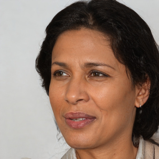 Joyful latino adult female with medium  brown hair and brown eyes