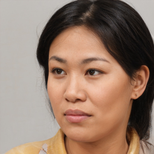 Joyful asian young-adult female with medium  brown hair and brown eyes