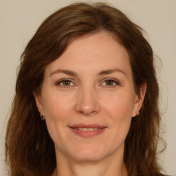 Joyful white adult female with long  brown hair and green eyes