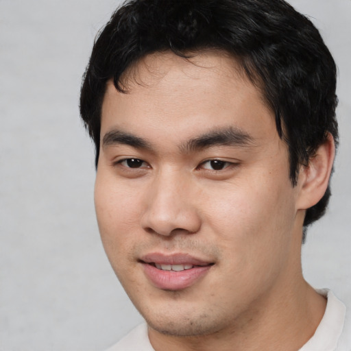 Joyful asian young-adult male with short  black hair and brown eyes