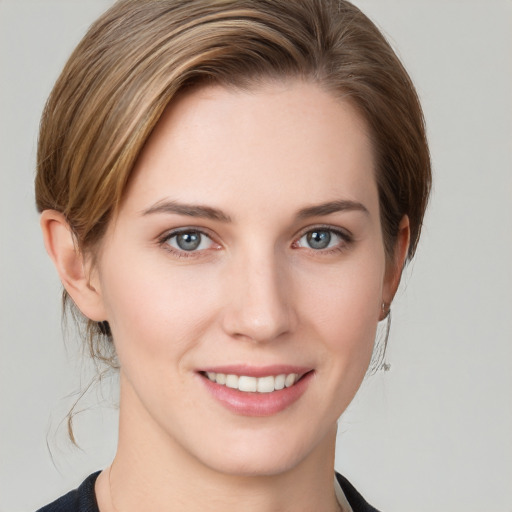 Joyful white young-adult female with medium  brown hair and grey eyes