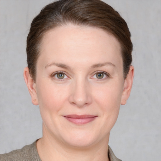 Joyful white young-adult female with short  brown hair and grey eyes