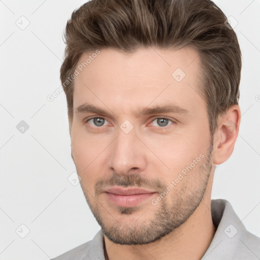 Joyful white young-adult male with short  brown hair and grey eyes