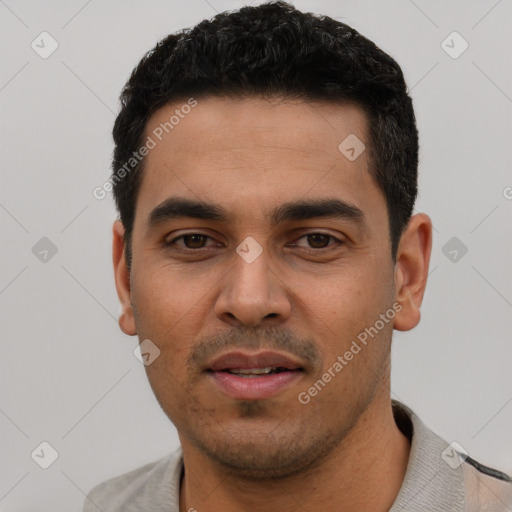 Joyful latino young-adult male with short  black hair and brown eyes