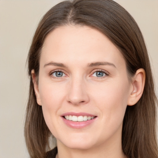 Joyful white young-adult female with long  brown hair and grey eyes