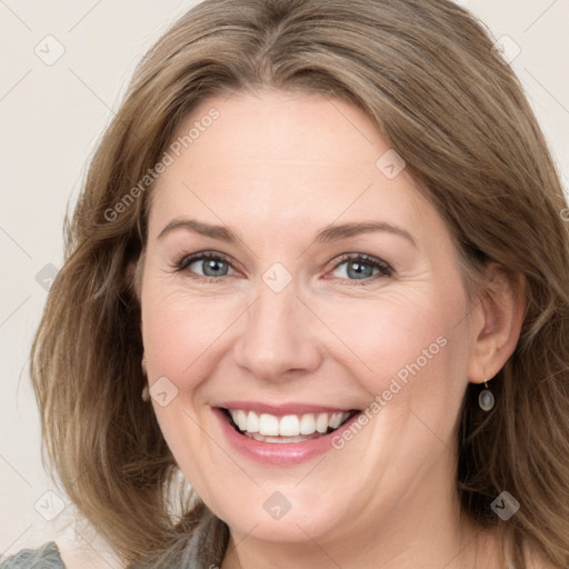 Joyful white adult female with long  brown hair and grey eyes