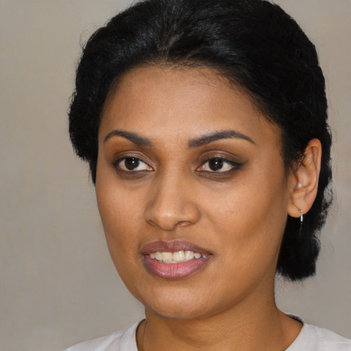 Joyful black young-adult female with short  black hair and brown eyes