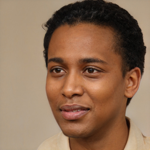 Joyful black young-adult male with short  black hair and brown eyes