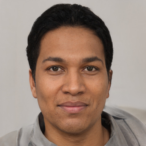 Joyful latino adult male with short  black hair and brown eyes