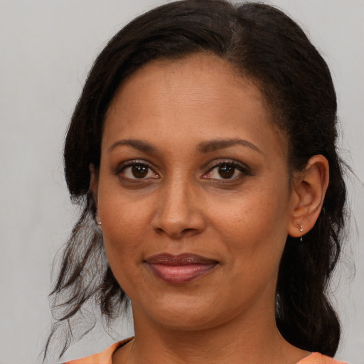 Joyful black young-adult female with medium  brown hair and brown eyes