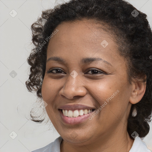 Joyful black young-adult female with medium  brown hair and brown eyes