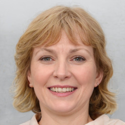 Joyful white adult female with medium  brown hair and blue eyes