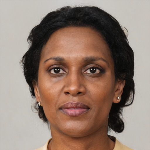 Joyful black adult female with medium  brown hair and brown eyes