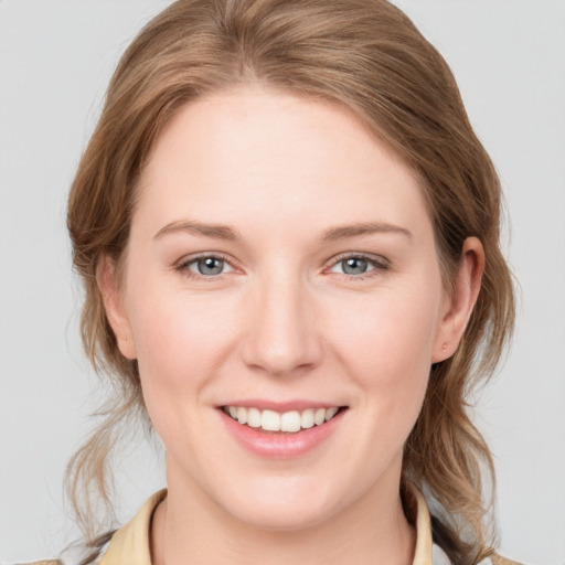 Joyful white young-adult female with medium  brown hair and grey eyes