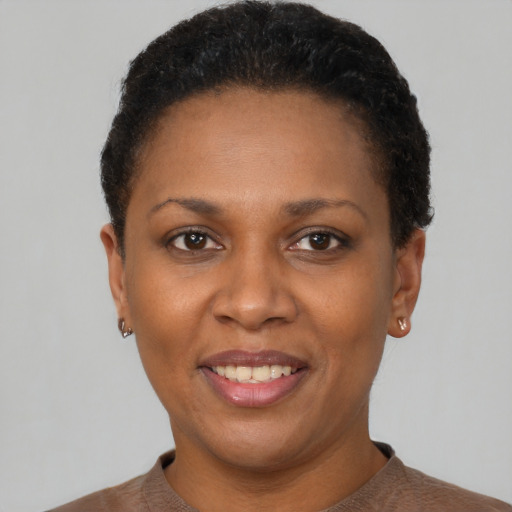 Joyful black adult female with short  black hair and brown eyes