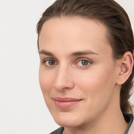 Joyful white young-adult female with medium  brown hair and grey eyes