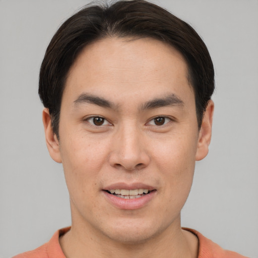 Joyful asian young-adult male with short  brown hair and brown eyes