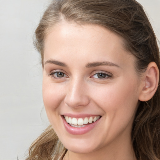 Joyful white young-adult female with long  brown hair and grey eyes