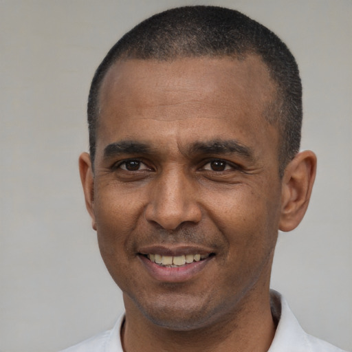Joyful black adult male with short  black hair and brown eyes