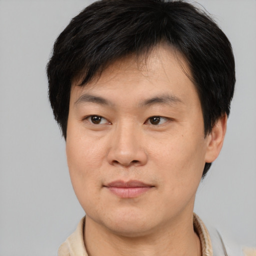 Joyful asian young-adult male with short  brown hair and brown eyes
