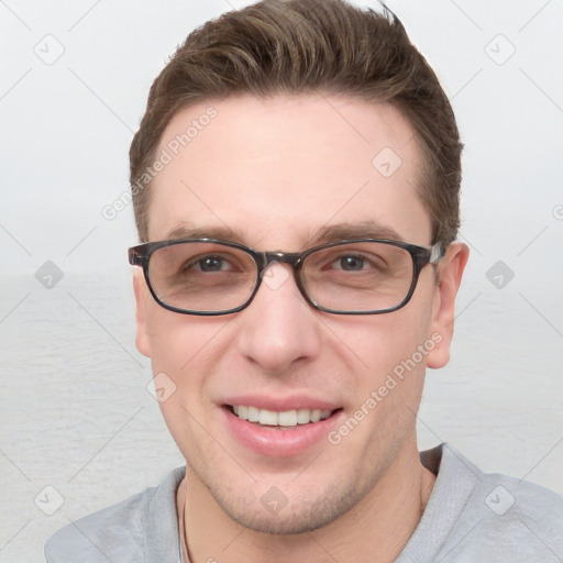 Joyful white young-adult male with short  brown hair and blue eyes