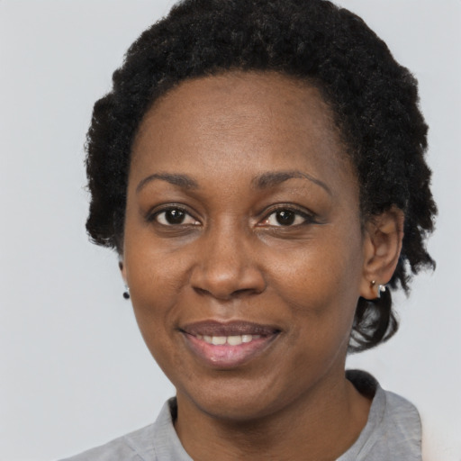 Joyful black adult female with short  black hair and brown eyes