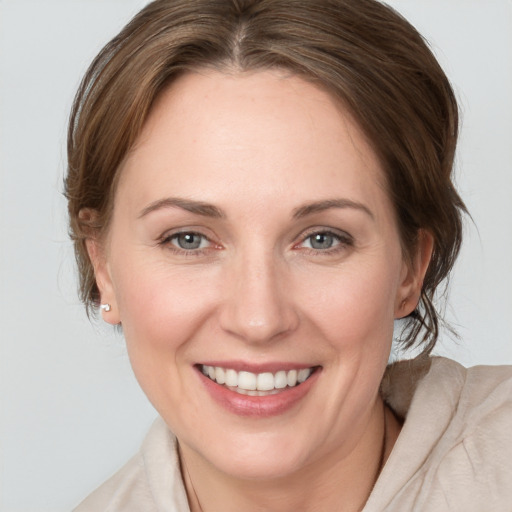 Joyful white young-adult female with medium  brown hair and grey eyes