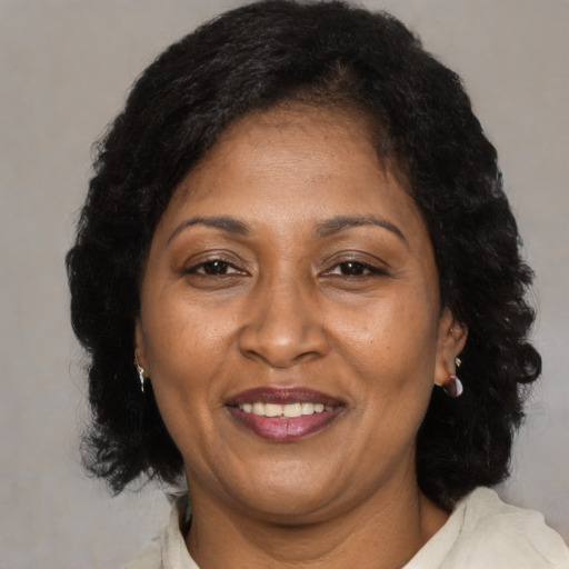 Joyful black adult female with medium  brown hair and brown eyes