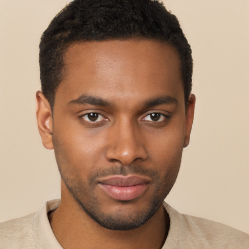 Joyful black young-adult male with short  brown hair and brown eyes