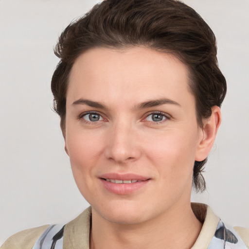 Joyful white young-adult female with short  brown hair and grey eyes