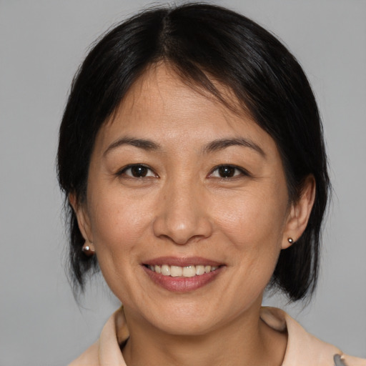 Joyful asian young-adult female with medium  brown hair and brown eyes