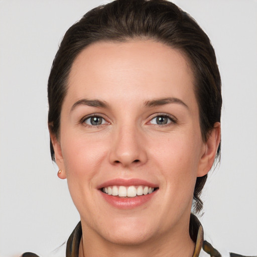 Joyful white young-adult female with short  brown hair and grey eyes