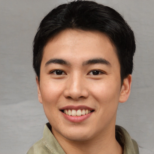 Joyful asian young-adult male with short  black hair and brown eyes