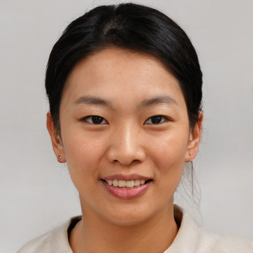 Joyful asian young-adult female with short  black hair and brown eyes