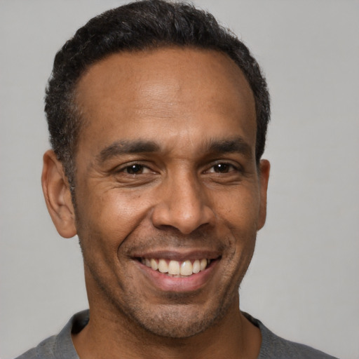 Joyful latino adult male with short  black hair and brown eyes