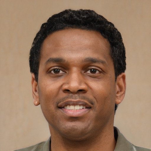 Joyful black young-adult male with short  black hair and brown eyes