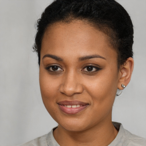 Joyful black young-adult female with short  brown hair and brown eyes